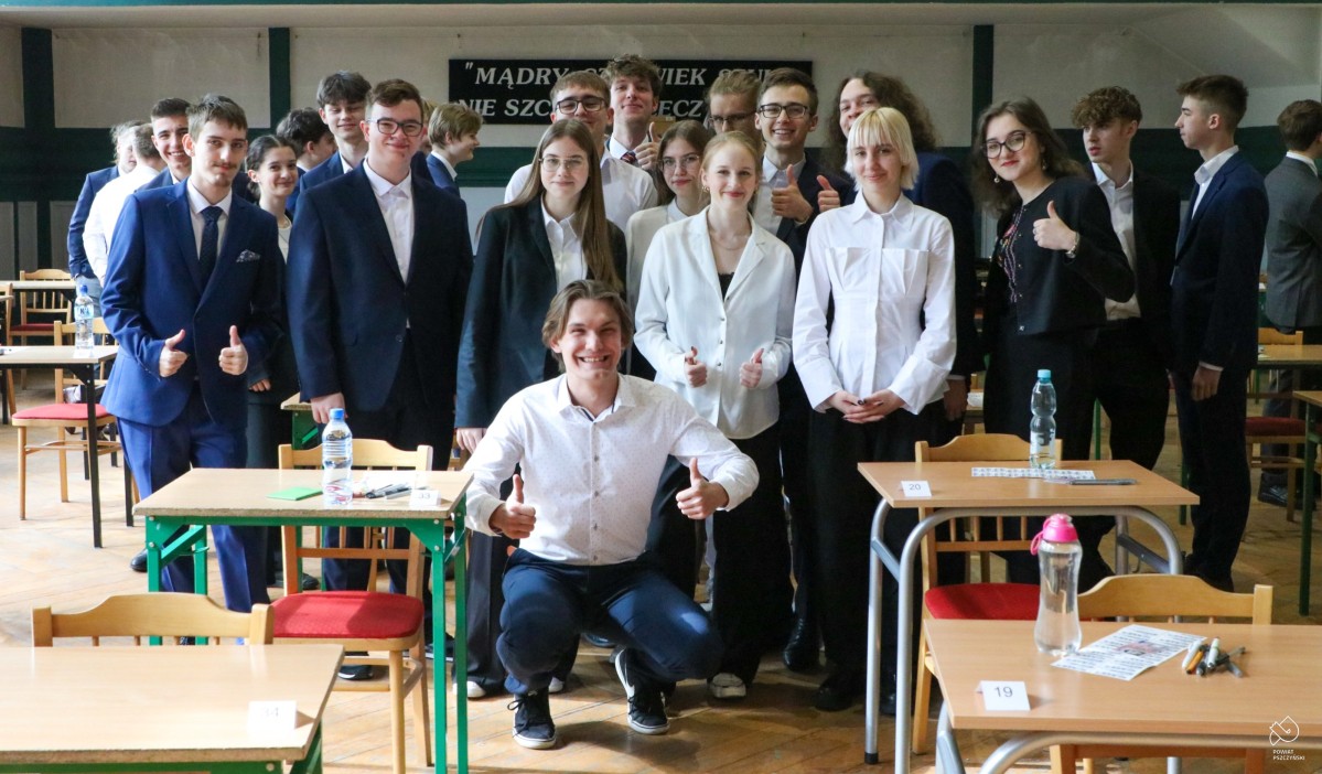 Maturzyści stoją w grupie obok siebie.