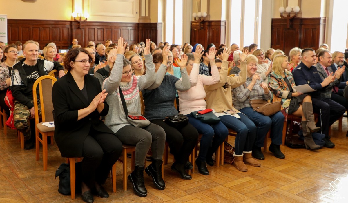 uczestnicy siedzący na krzesłach w sali narad