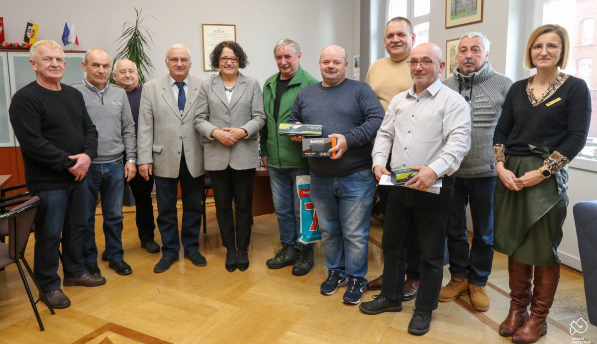 Przedstawiciele społecznej straży rybackiej razem ze starostą stoją w jej gabinecie,