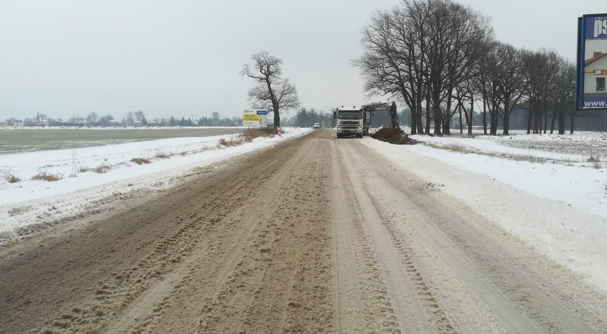 Droga Wojewódzka 933. Śnieg. W oddali widoczna koparka.