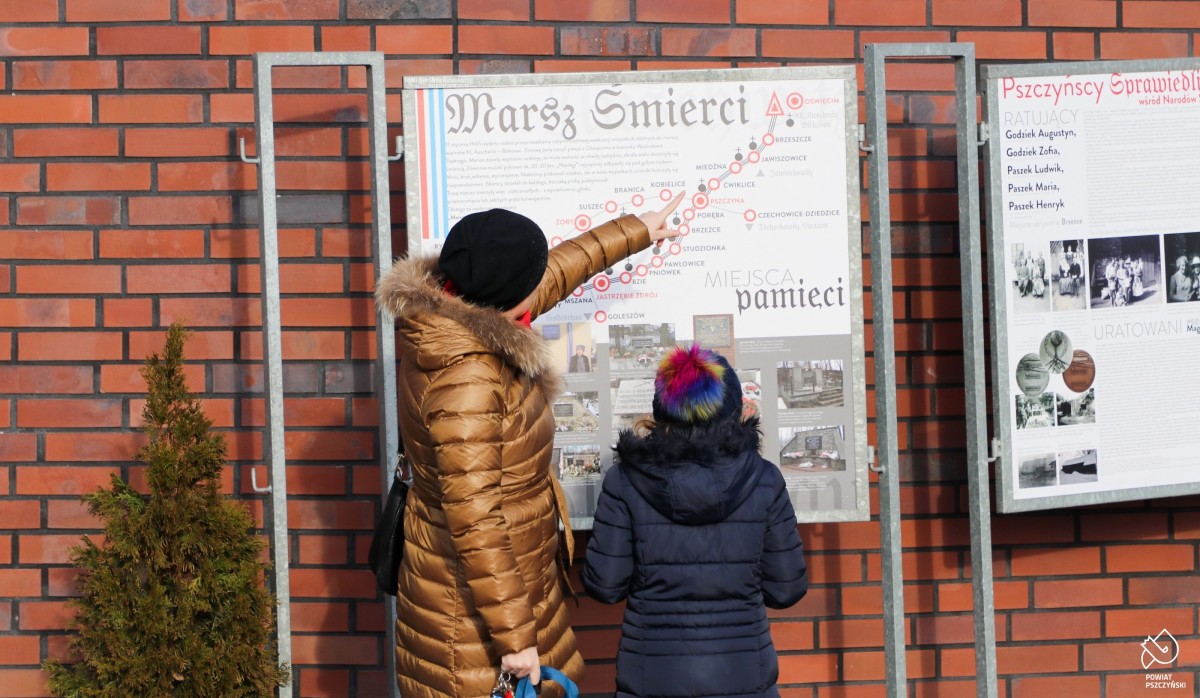 Kobieta z dziewczyną oglądają tablice z historią Pszczyńskich Sprawiedliwych.