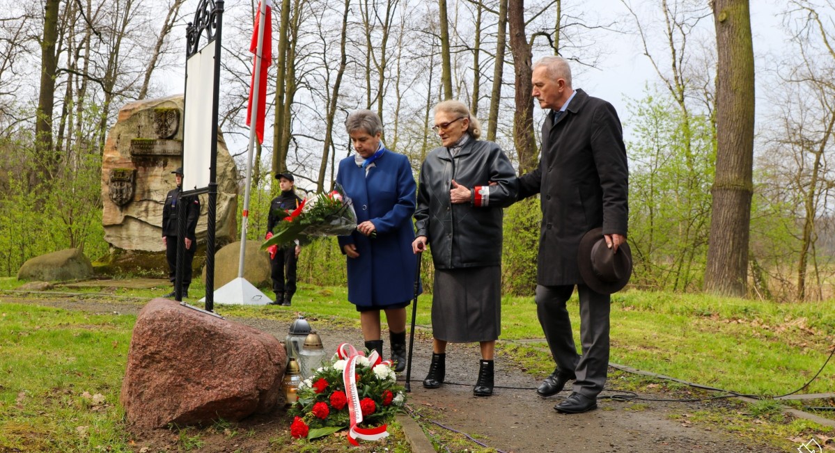 Pszczyńskie Sybiraczki i członek zarządu powiatu składają kwiaty pod Dębem Katyńskim