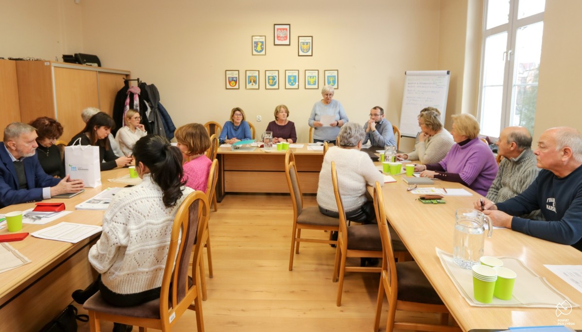 Członkowie Forum Seniorów podczas kolejnego posiedzenia. Siedzą przy stole ułożonym w podkowę.