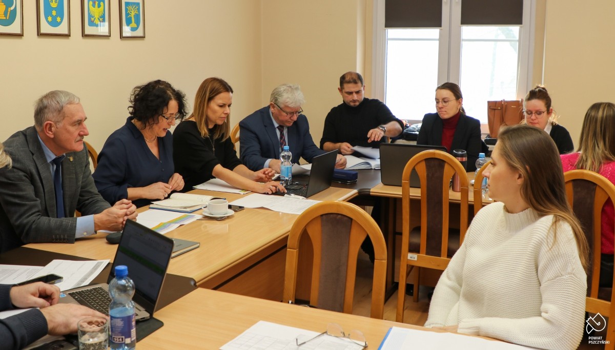 Przedstawiciele, gmin, powiatu i szpitala w małej sali sesyjnej siedzą za stołami.
