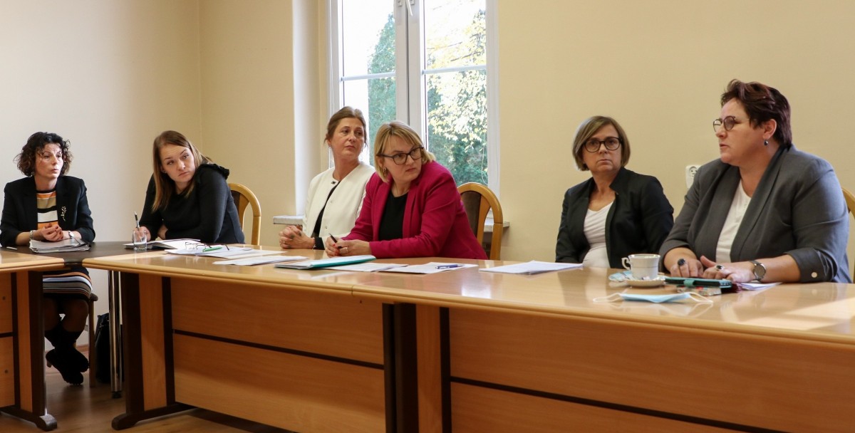 W starostwie powiatowym trwaspotkanie, za stołem siedzą kobiety - przedstawicielki pieczy zastępczej w regionie.