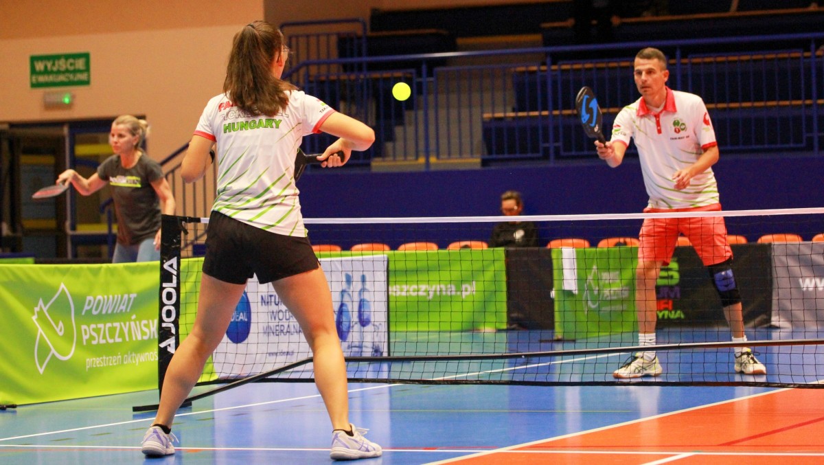 Zawodnicy grające na hali w pickleballa.