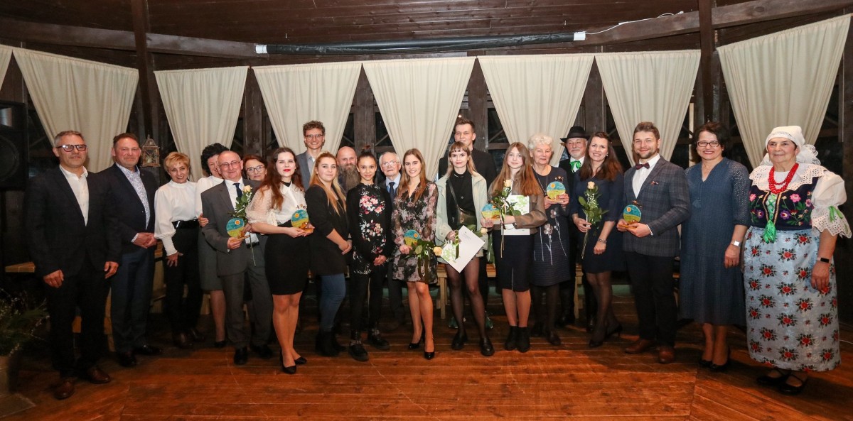 Grupa laureatów nagród starosty, wnioskodawcy oraz włodarze powiatu w altanie w skansenie