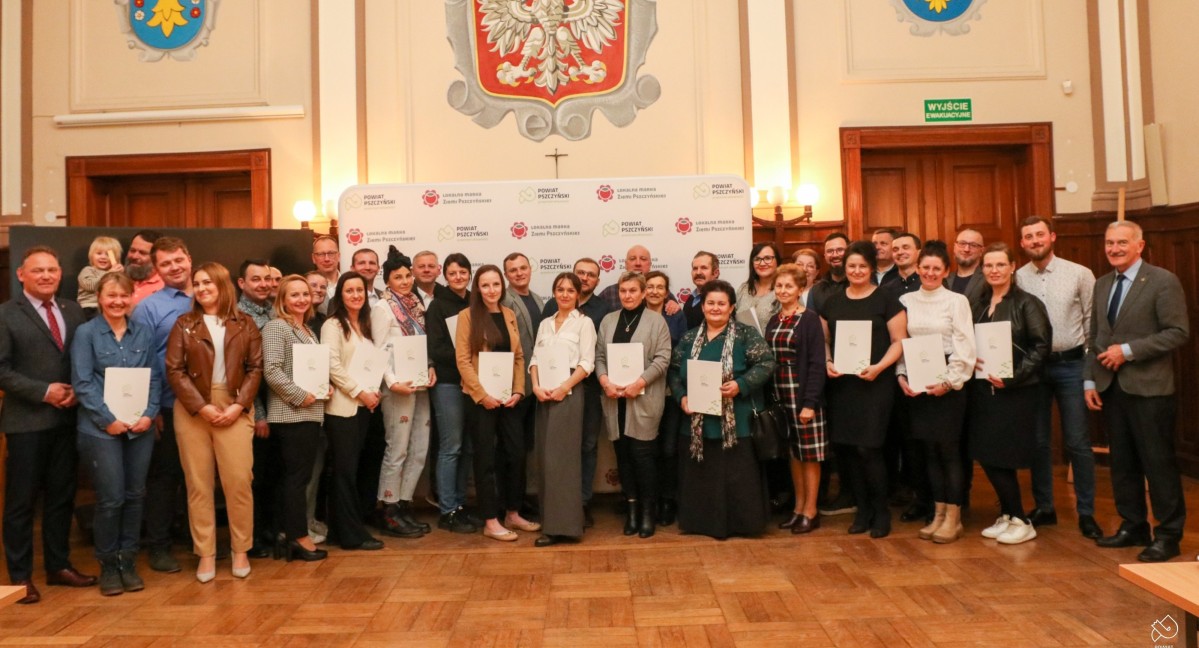 producenci lokalnej marki stoją na wspólnym zdjęciu w sali sesyjnej starostwa