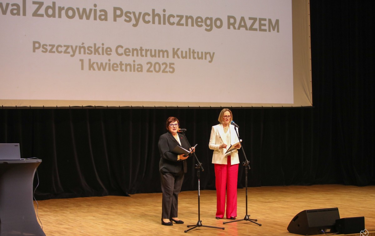 Dwie kobiety stoją na scenie pckulu i mówią do mikrofonu