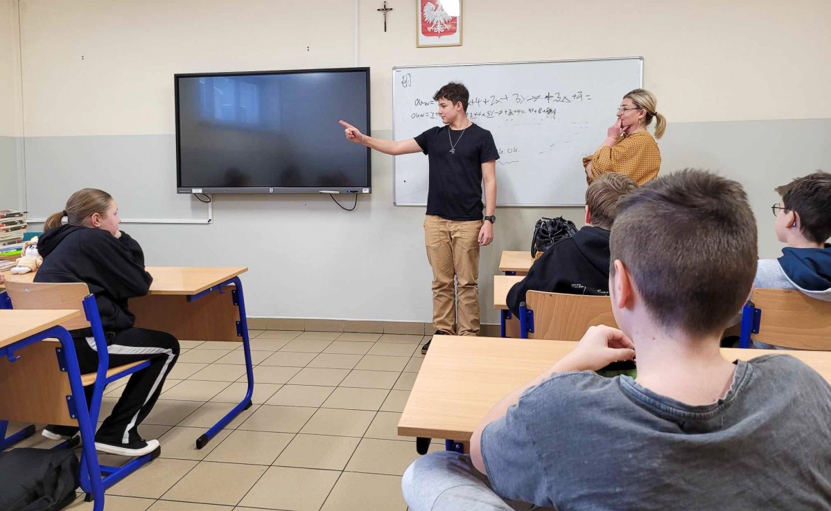 Uczeń pokazujący znaki w języku migowym.