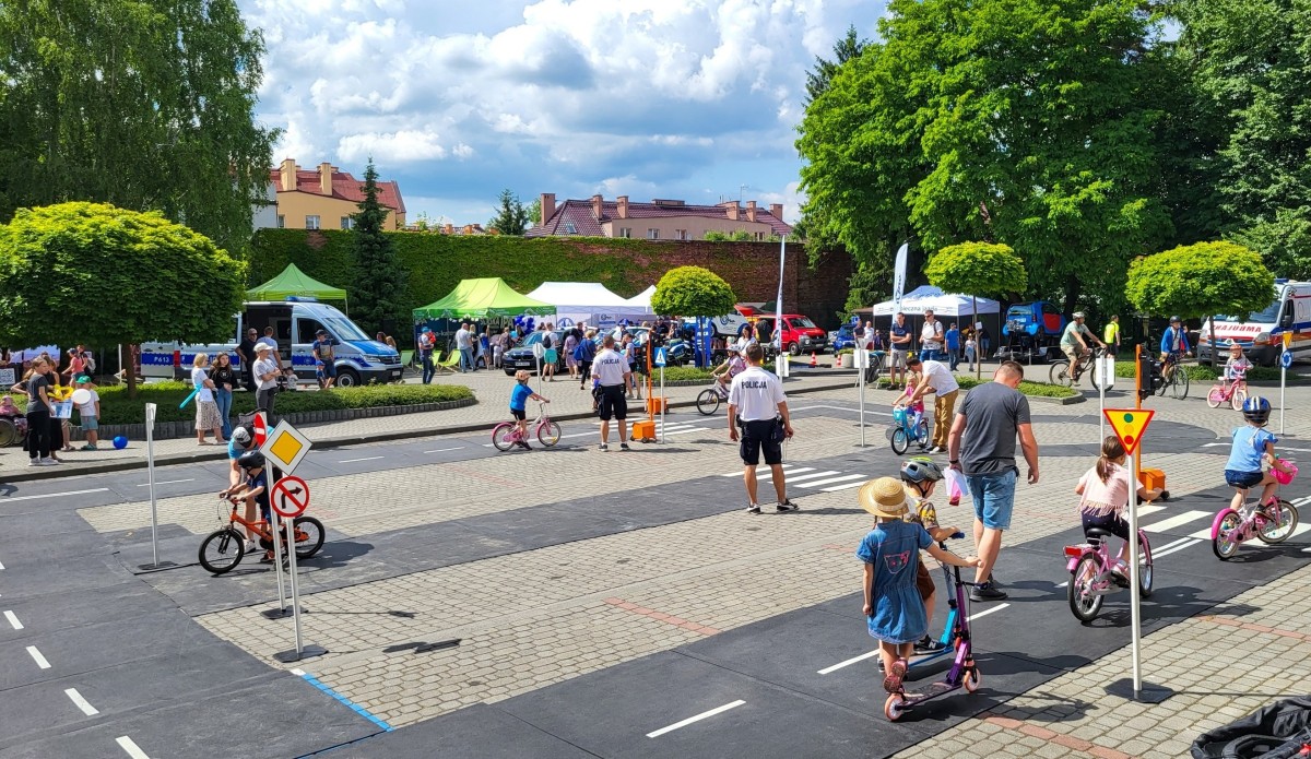 Na parkingu rozłożono w miasteczku ruchu drogowego, po którym dzieci jeżdżą na rowerach i hulajnogach