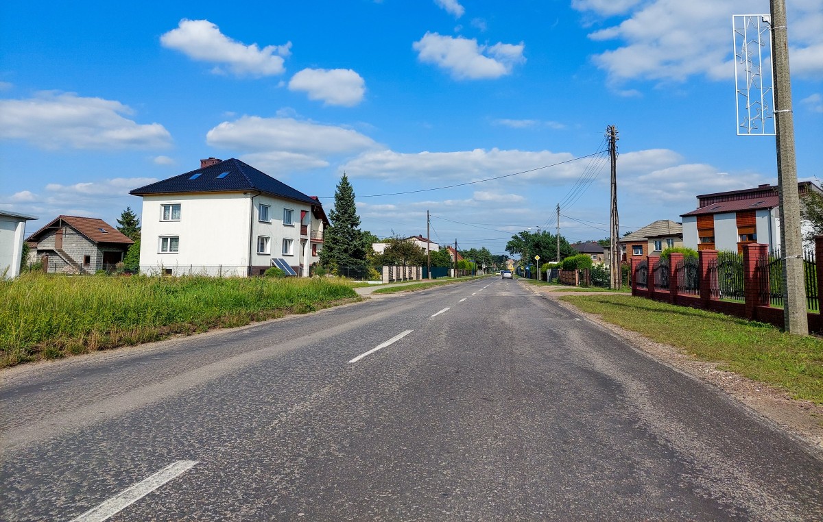 Ulica Pszczyńska w Woli. Nierówna droga pomiędzy domami.