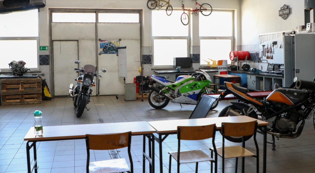 Pracownia motoryzacyjna w warsztatach szkolnych, duże jasne pomieszczenie, w którym stoją motocykle.