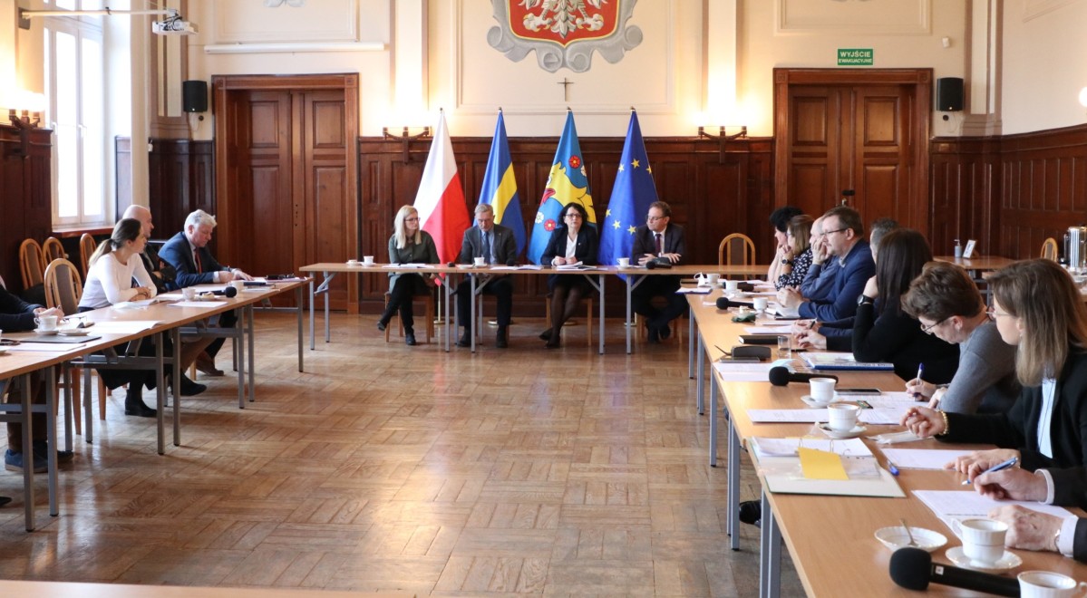 Na duzej sali trwa konwent włodarzy z powiatu. Uczestnicy siedzą za stołami.
