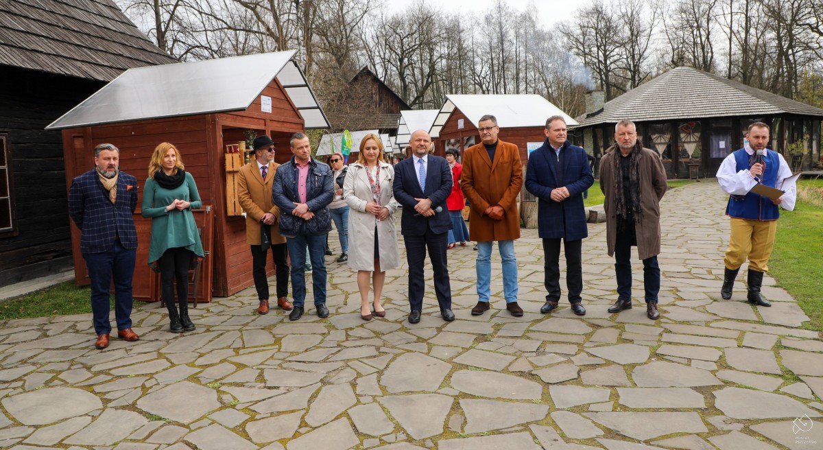 Samorządowcy, organizatorzy, współorganizatorzy i goście na tle stoisk.