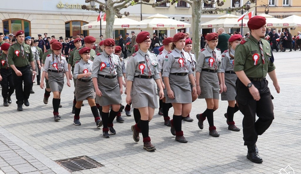 Pochód uczestników obchodów rocznicy Uhwalenia Konstytucji 3 Maja. Na pszczyńksim rynku maszerują młodzi harcerze.