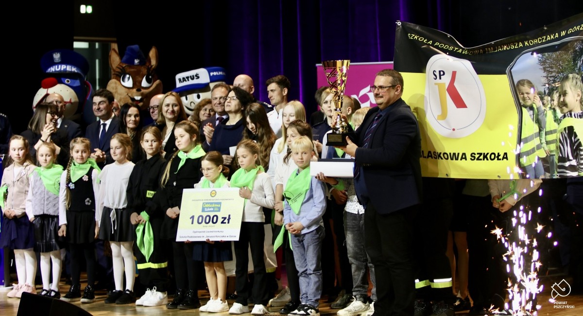 Dyrektor Szkoły w Górze z pucharem, uczniowie i goście na scenie.