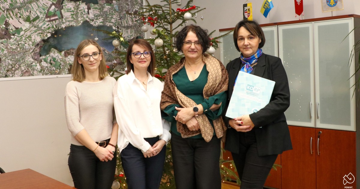 starosta, dyrektor poradni oraz pracownice wydziału zdrowia na wspólnym zdjęciu. Jedna trzyma część zakkupionych testów