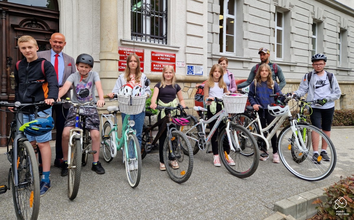 Uczniowie stoją przy swoich rowerach przed budynkiem starostwa.