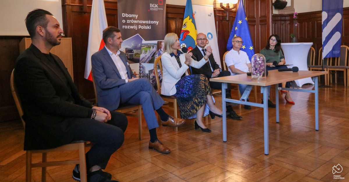 Eksperci siedzana krzesłach w sali sesyjnej podczas konferencji