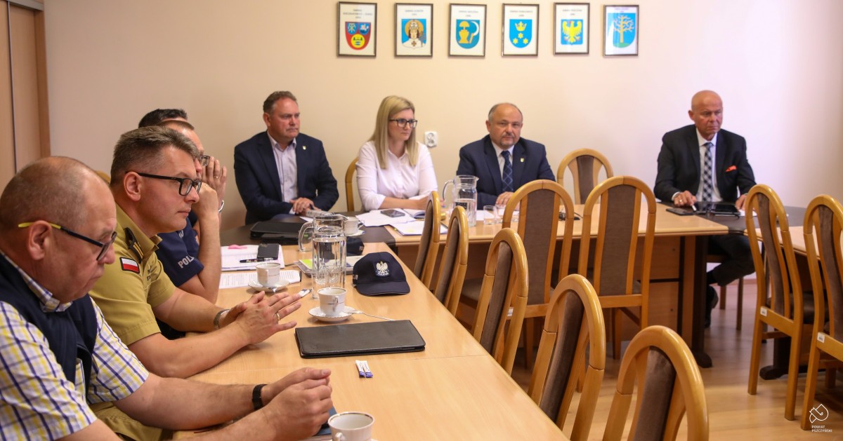 Za stołami w salce konferecyjnej siedzą uczestnicy komisji, w tym przedstawiciele służb mundurowych
