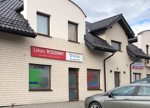 Budynek ośrodka zdrowia. przed nim zaparkowany samochód