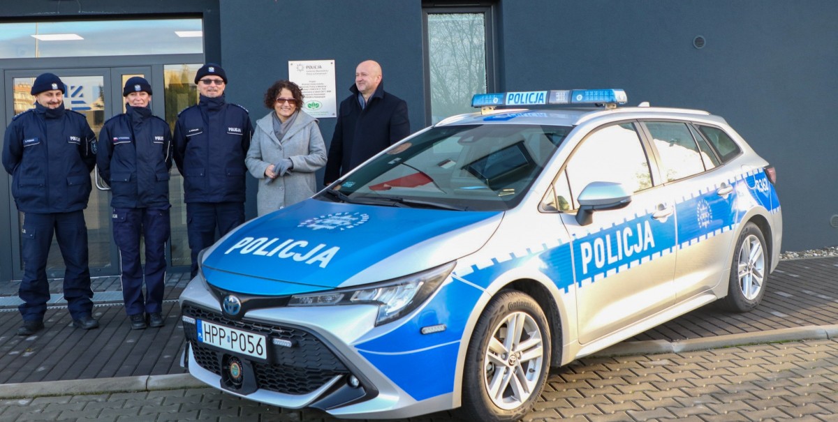 Przed komisariatem policji stoi nowy radiowóz przy nim starosta, wójt i policjanci
