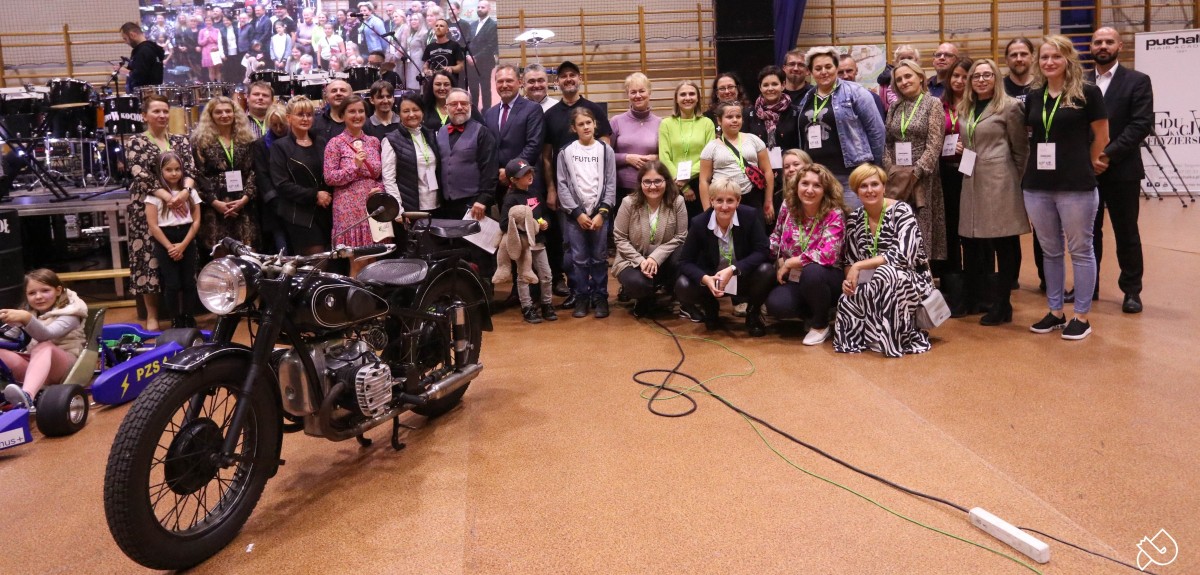 Grupa nauczycieli i uczniów pozuje do wspólnego zdjęcia.