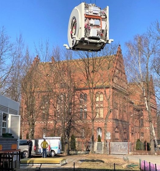 Dźwig umieszcza rezonans magnetyczny w modułowym przy szpitalu.