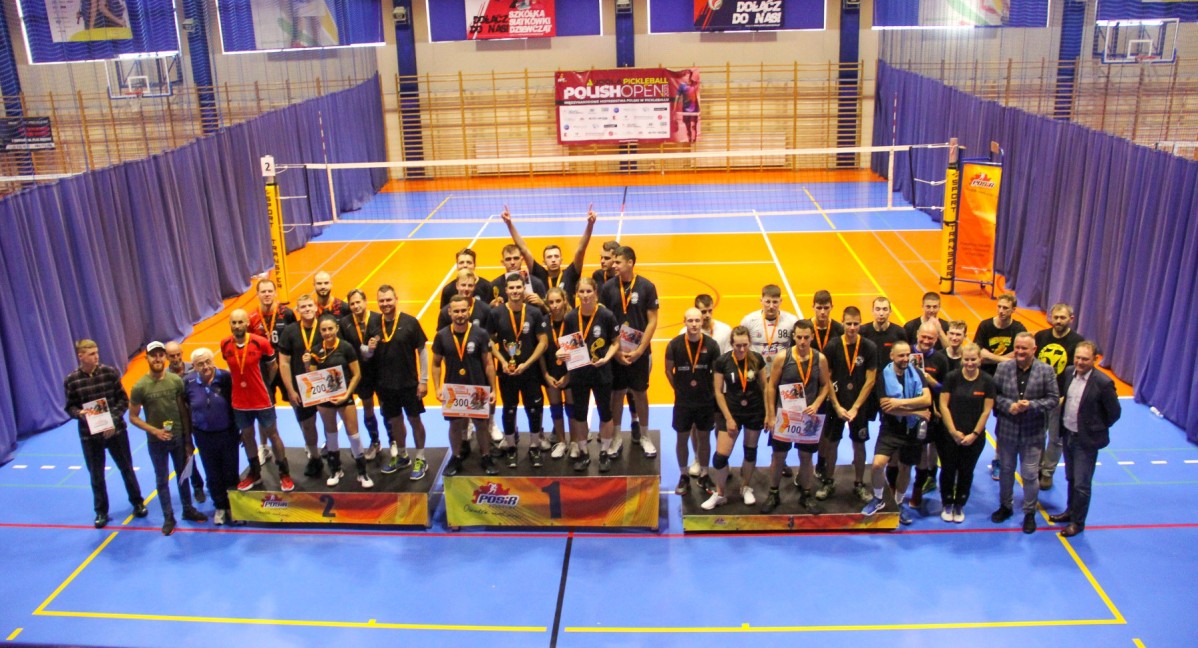 Zwycięskie drużyny na podium w hali.