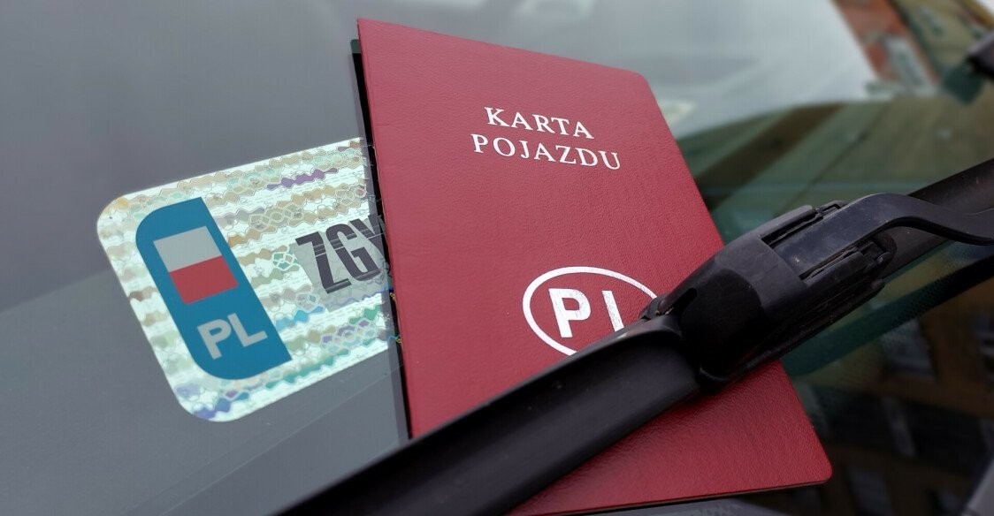 Naklejka kontrolna naklejona na szybkę samochodu, za wycieraczkę włożona karta pojazdu.