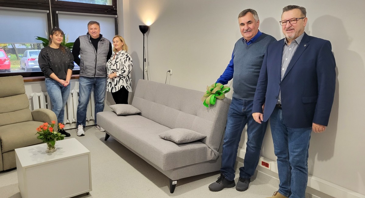 w pomieszczeniu radni stoją przy zakupionej kanapie wspólnie z kierownik poradni