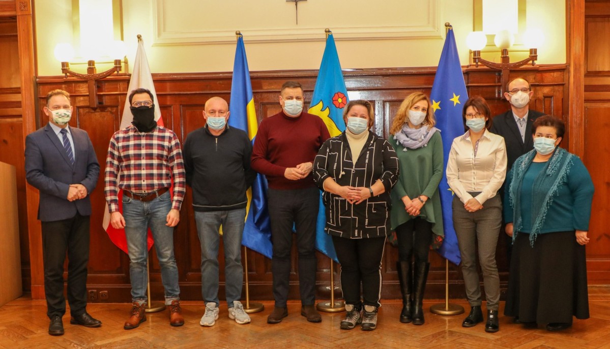 Członkowie komisji certyfikacyjnej stoją obok siebie w sali sesyjnej pszczyńskiego starostwa.