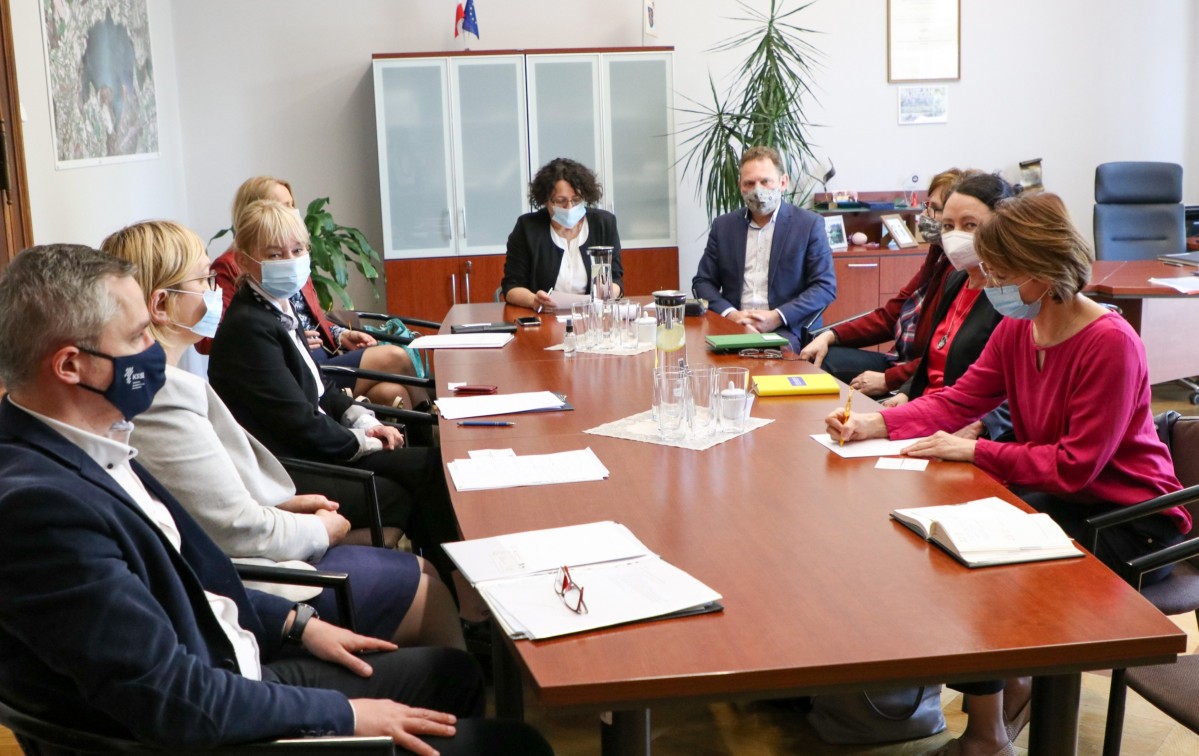 Przedstawiciele powiatu pszczyńskiego i KSSE w gabinecie starosty siedzący za długim stołem.