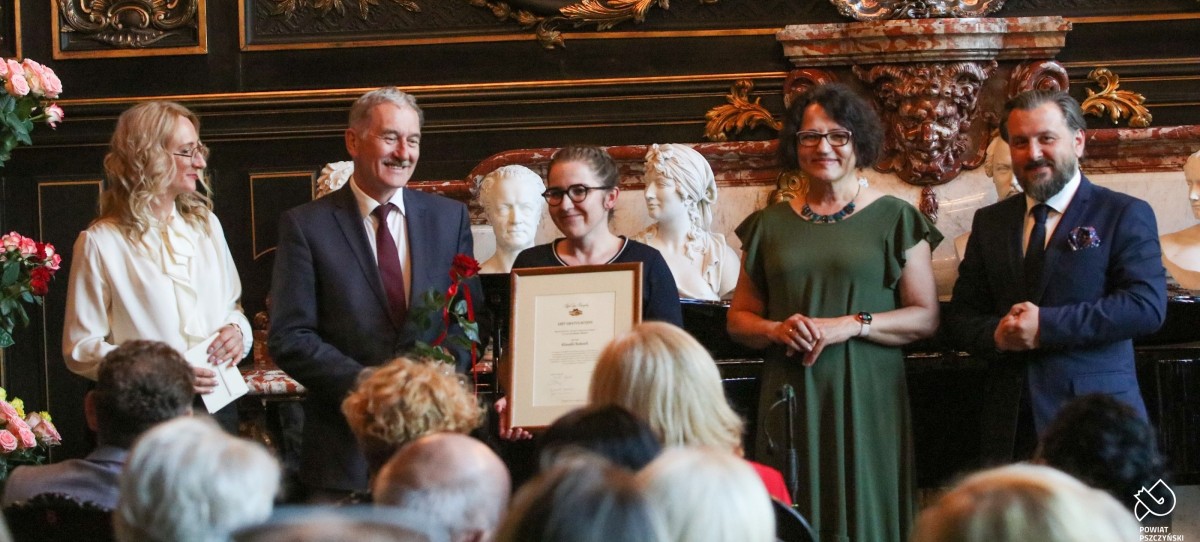 Laureatka Klaudia Roksela w towarzystwie osób wręczających wyróżnienie