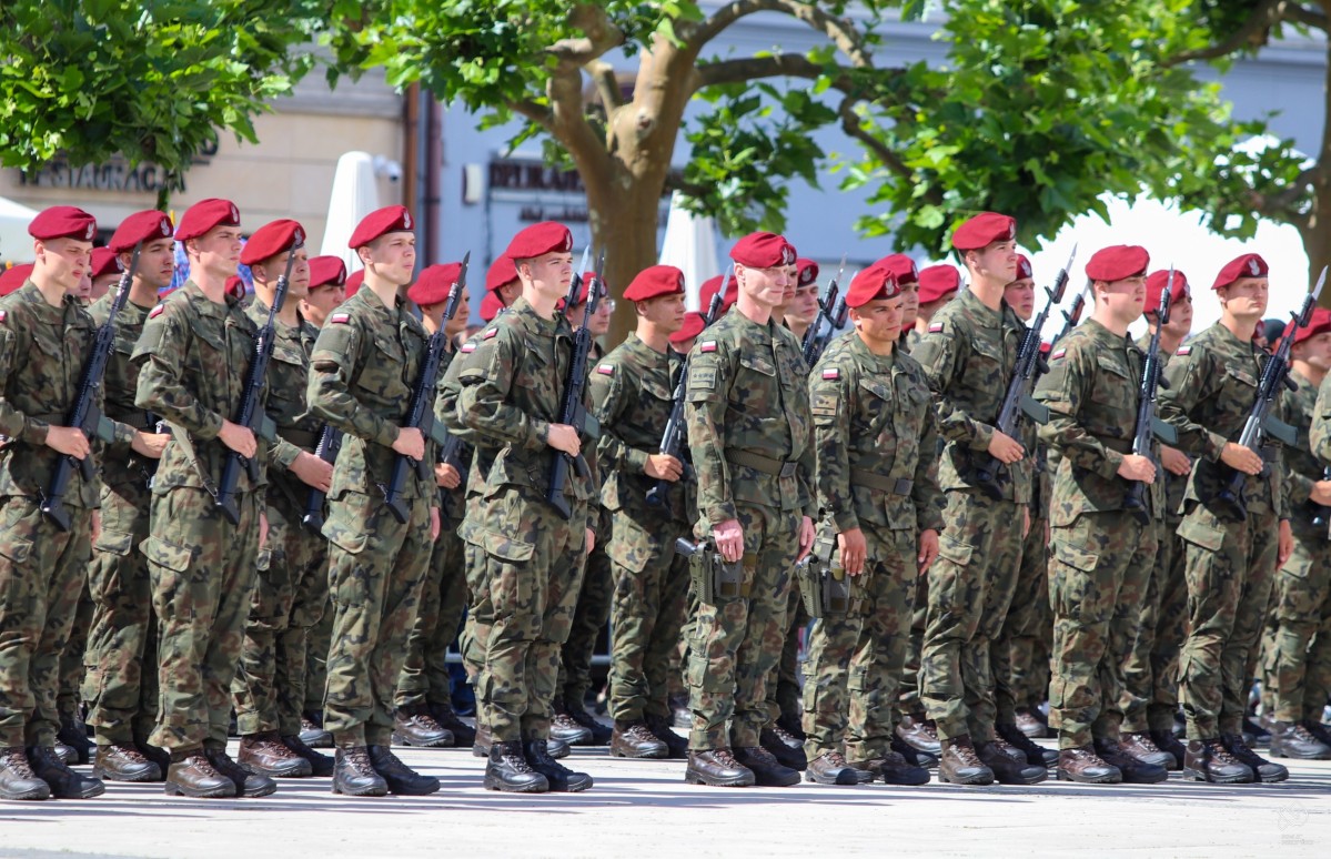 żołnierze ubrani w strój moro oraz bordowe berety stoją w zwartym szyku