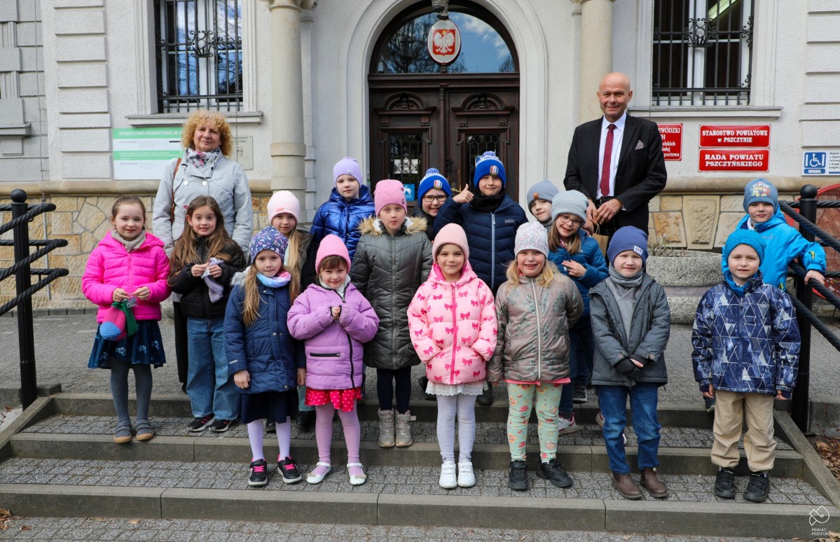 Dzieci z wychowawcą i Szymonem Sektą na schodach przed budynkiem Starostwa.