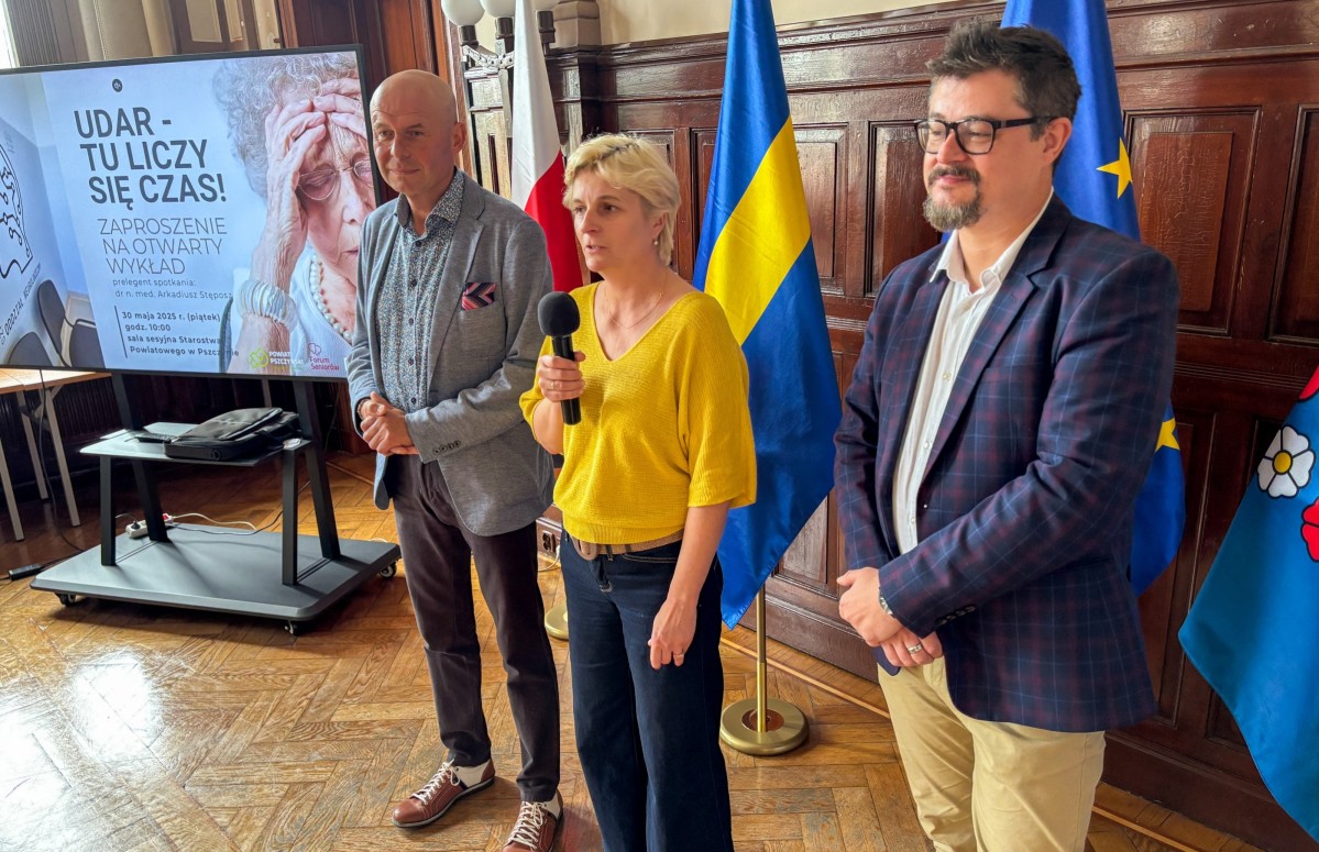 prezes szpitala, sekretarz powiatu i prelegent stoją w sali sesyjnej starostwa