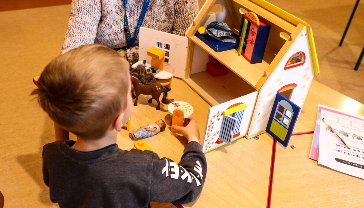 Chłopiec podczas zajęć w Poradni Psychologiczno-Pedagogicznej w Pszczynie. Układa elementy domku