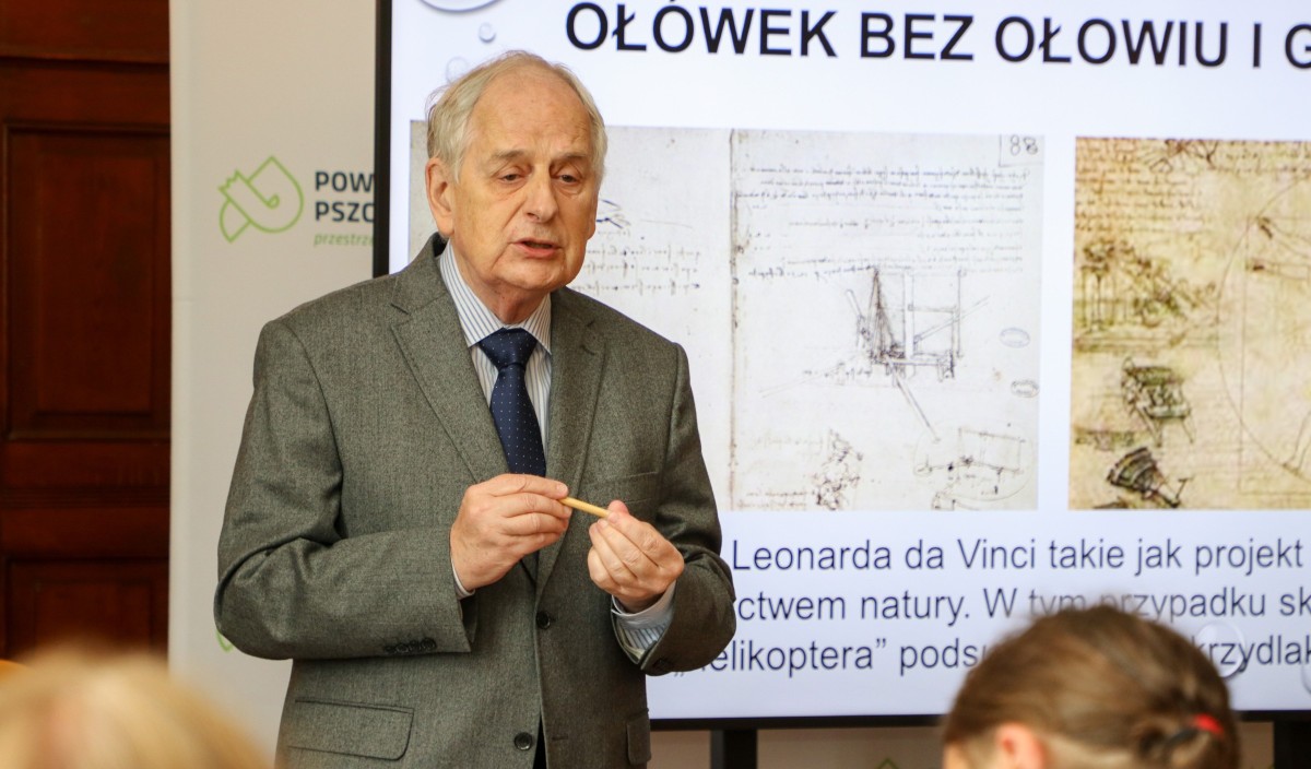 Redaktor głoszący wykład przed monitorem.