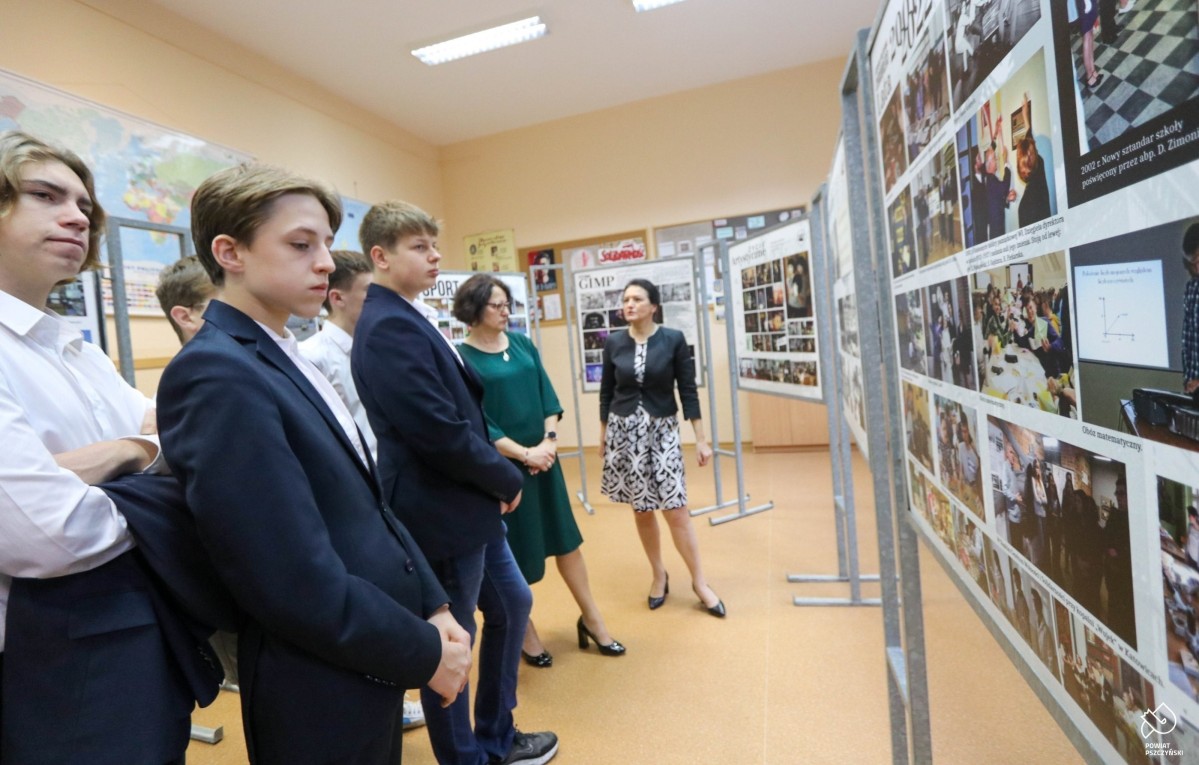 Uczniowie, starosta i dyrektor oglądają wystawę o historii I LO im. Bolesława Chrobrego w Pszczynie