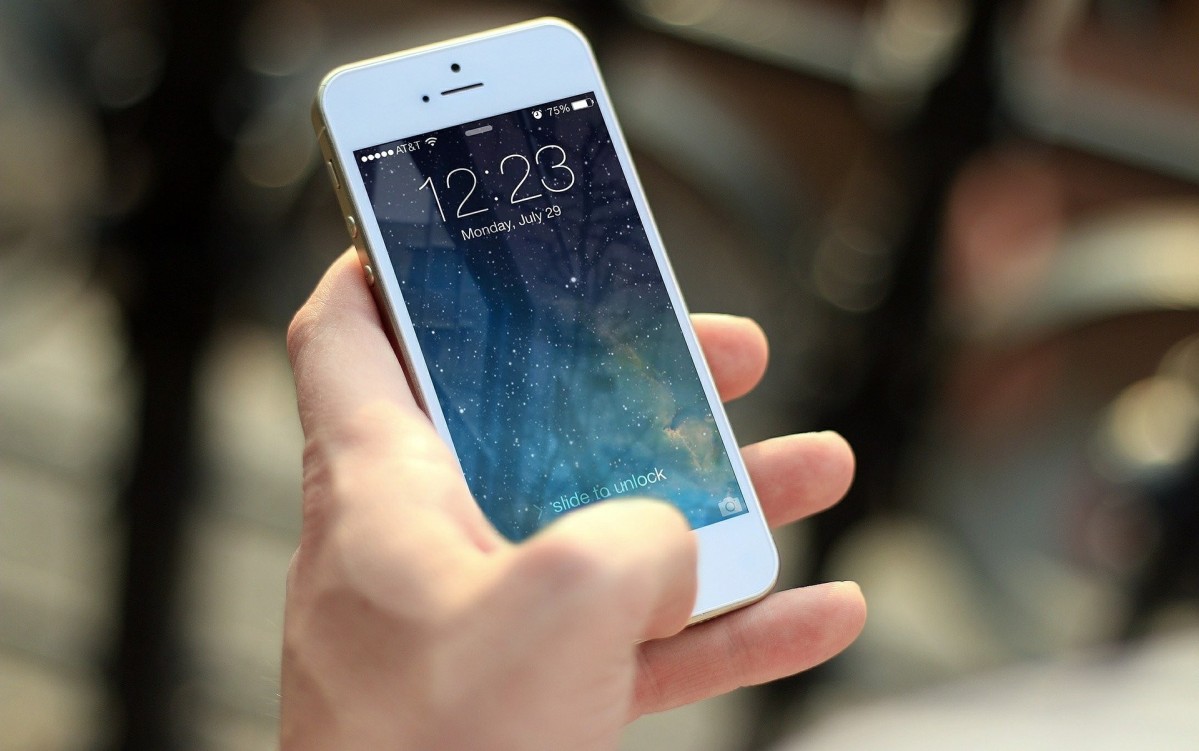 Dłoń trzymająca telefon komórkowy.