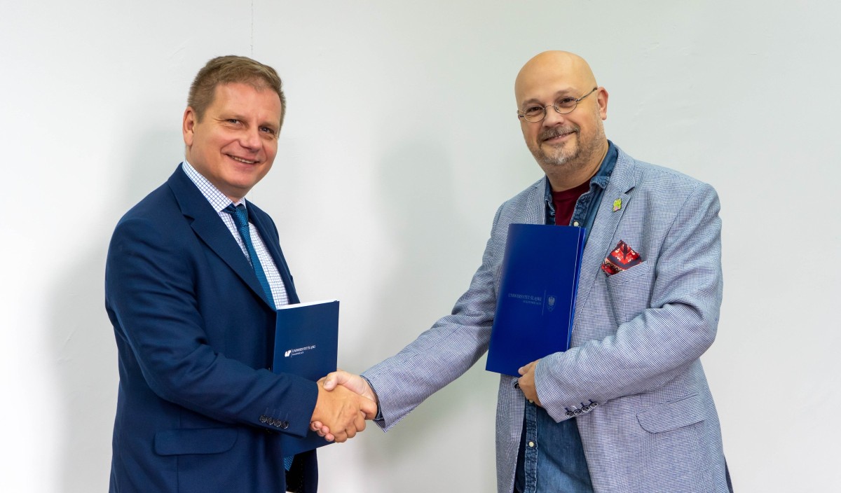 Dyrektor szkoły i dziekan wydziału ściskaja ręce po podpisaniu umowy