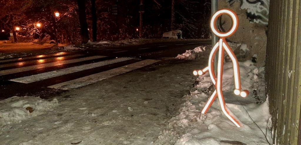 Odblaskowa sylwetka dziecka przy przejściu dla pieszych.