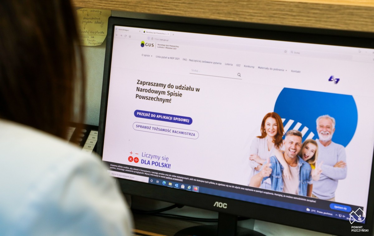 Kobieta siedząca przed ekranem komputera, na którym jest otwarta strona Narodowego Spisu Powszechnego.