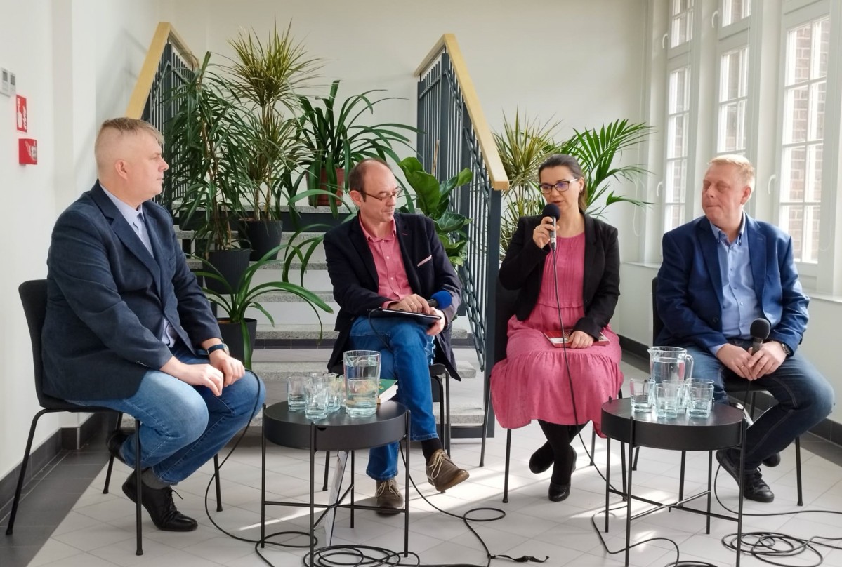 Wykładowcy podczas konferencji w Rybniku. Siedzą na krzesłach.