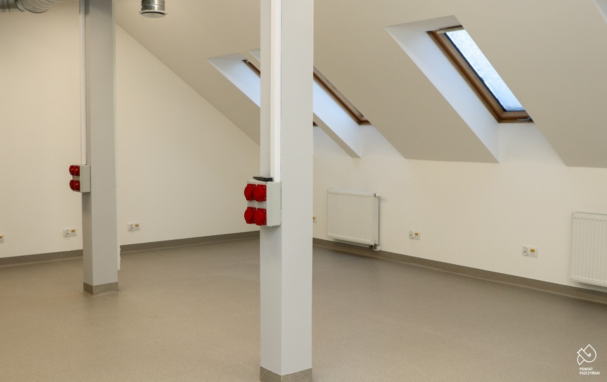 Sala pomalowana na biała, na ścianach pomontowane gniazdka.