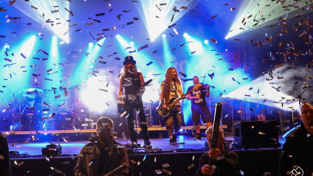 Na dużej scenie trwa koncert metalowego zespołu Hunter. Kolorowe światła i wystrzelone konfetti, na scenie muzycy