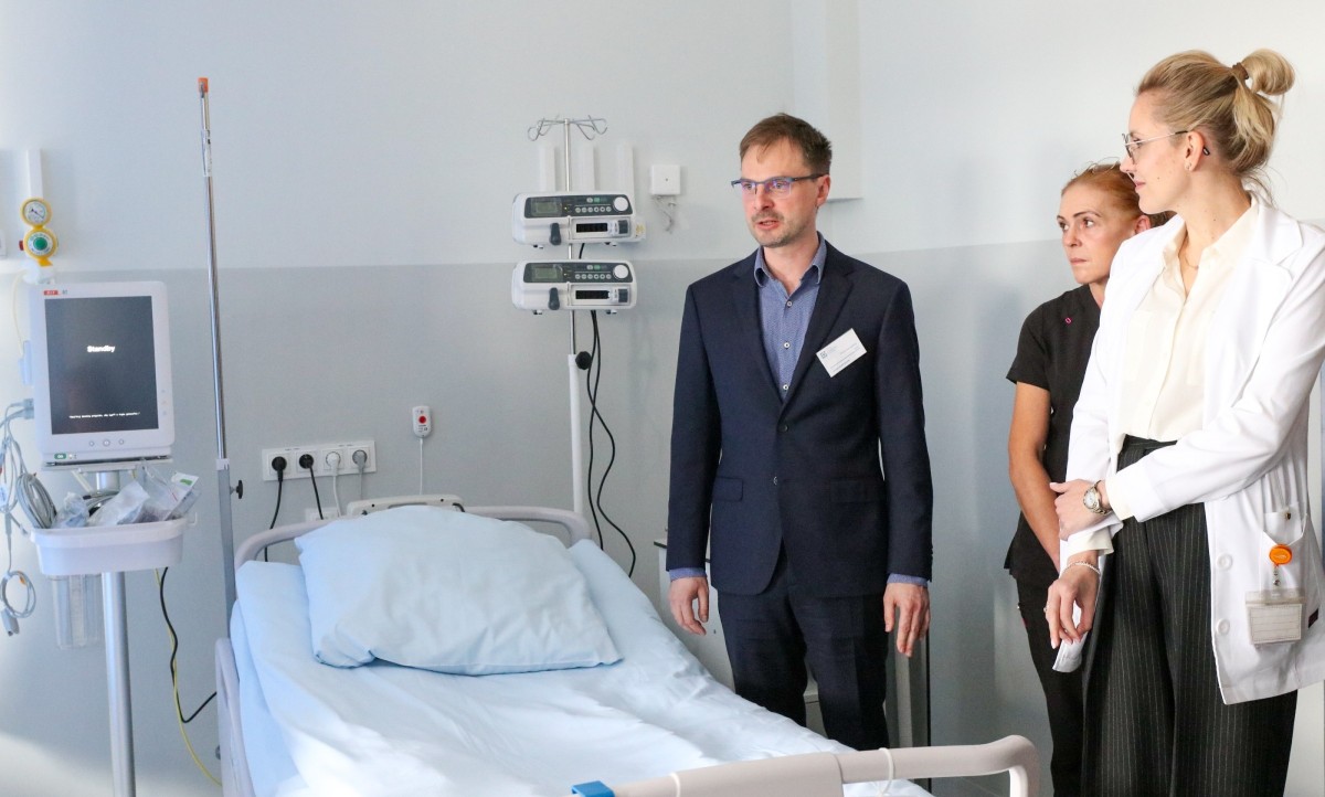 Wnętrze pododdziału udarowego, przy łózku stoją lekarze oraz oddziałowa