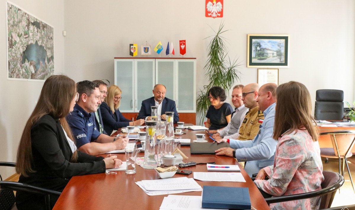 Członkowie komisji bezpieczeństwa siedzą za stołem w gabinecie starosty